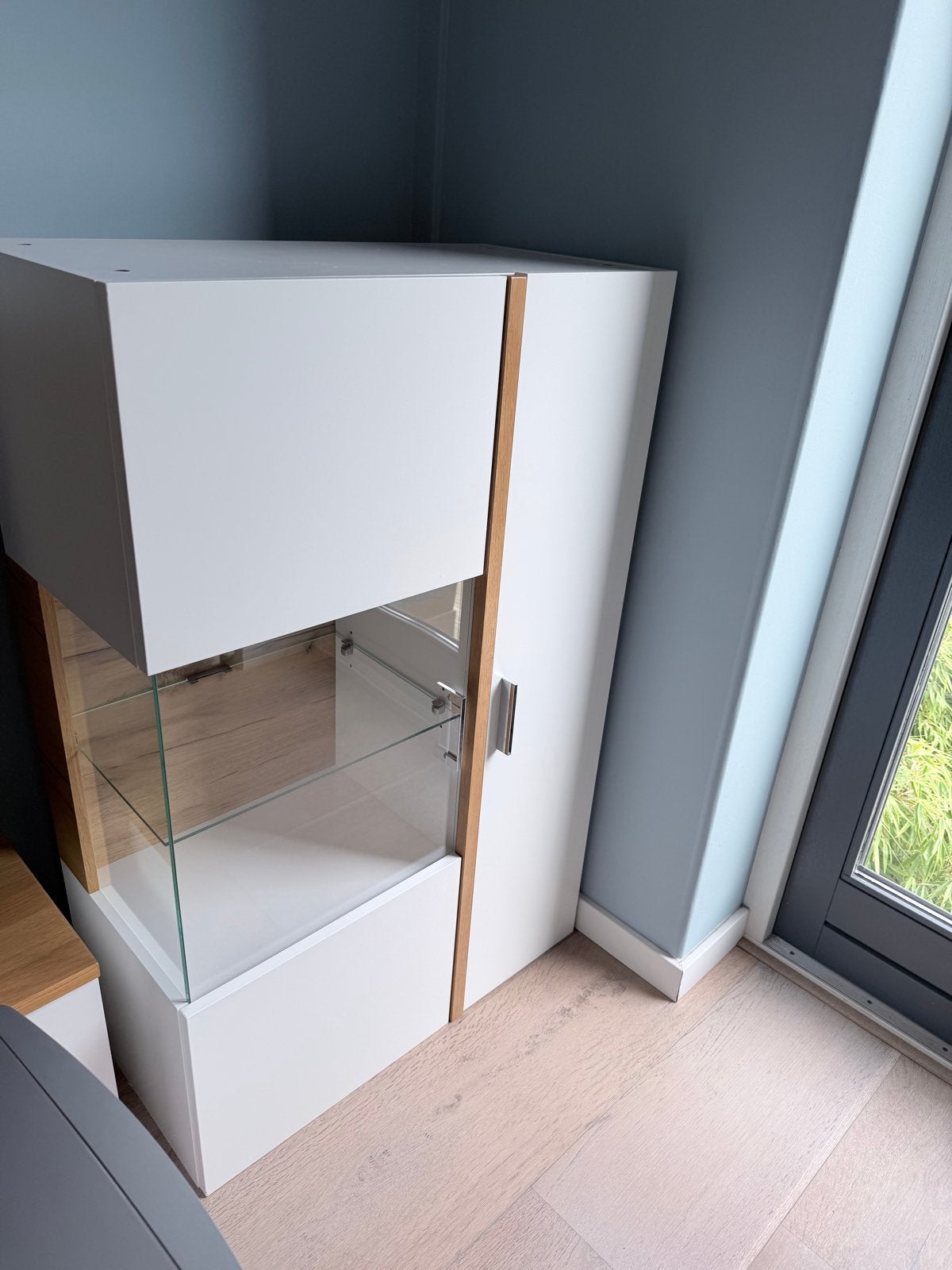 Foto 5 van Witte wandkast met glazen vitrine en houten accenten