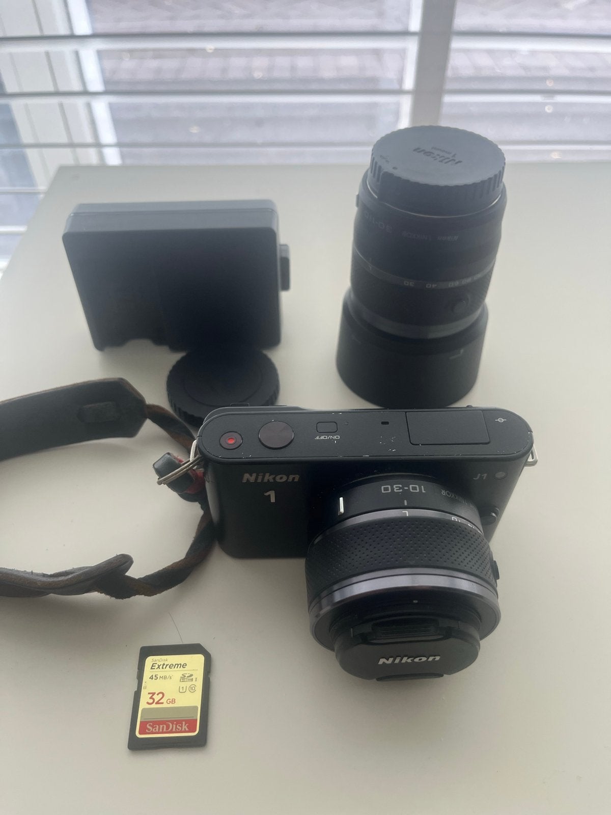 Nikon 1 J1 Systeemcamera met 2 lenzen en 32GB SD-kaart, Ingebouwde flitser, Ophalen of Verzenden, Zo goed als nieuw, Accu