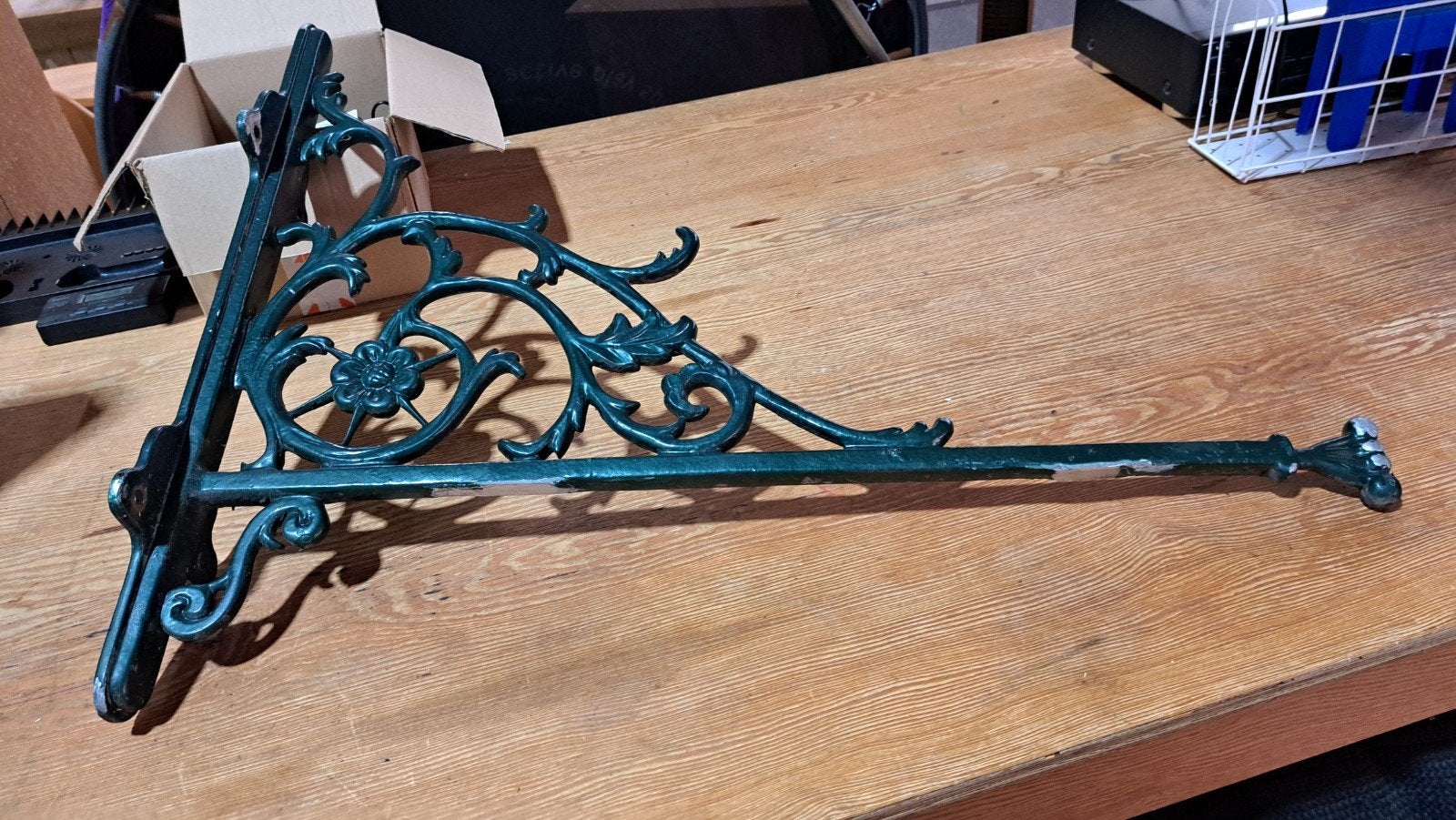 Antieke metalen uithangbordbeugel met bloemmotief, Ophalen