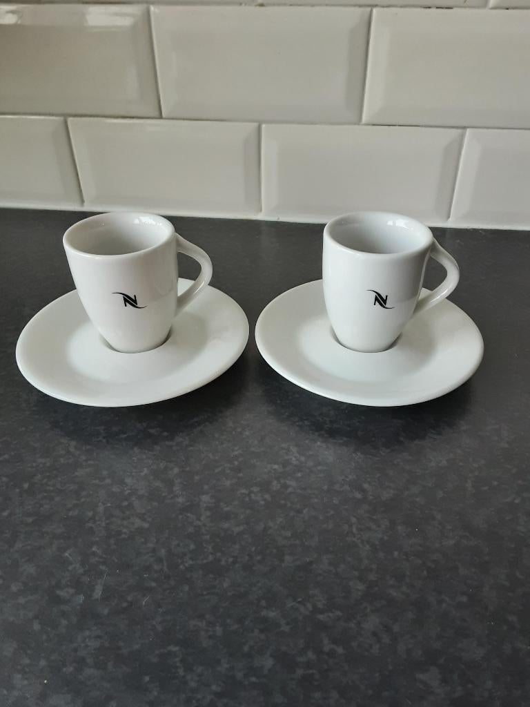 NESPRESSO special club 1999 kopjes met schoteltjes 2 st., Ophalen of Verzenden, Zo goed als nieuw, Overige stijlen, Kop(pen) en/of Schotel(s)