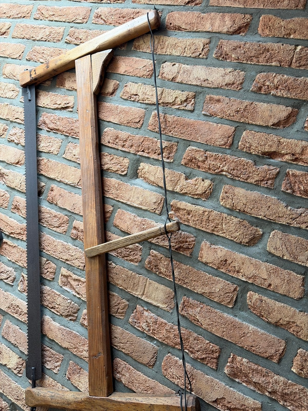 Oude handzaag met houten frame, Ophalen