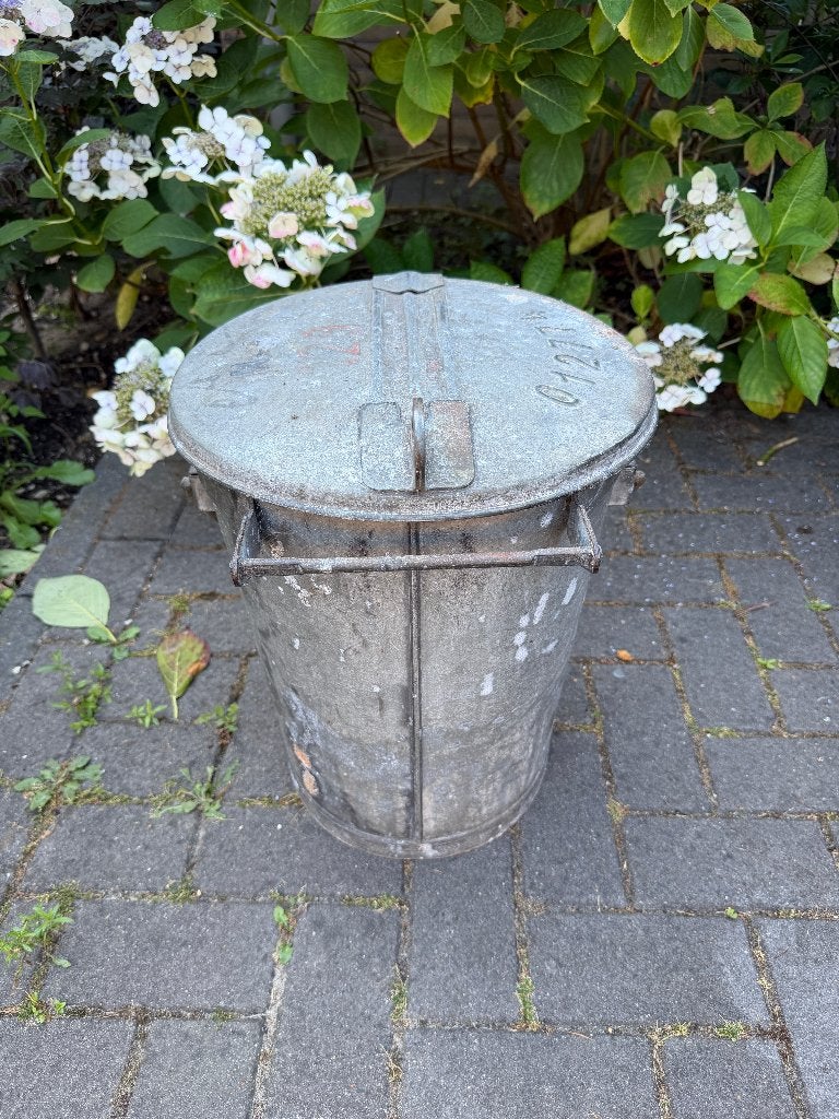 Zinken vuilnisemmer met opschrift N-A 012774, Ophalen
