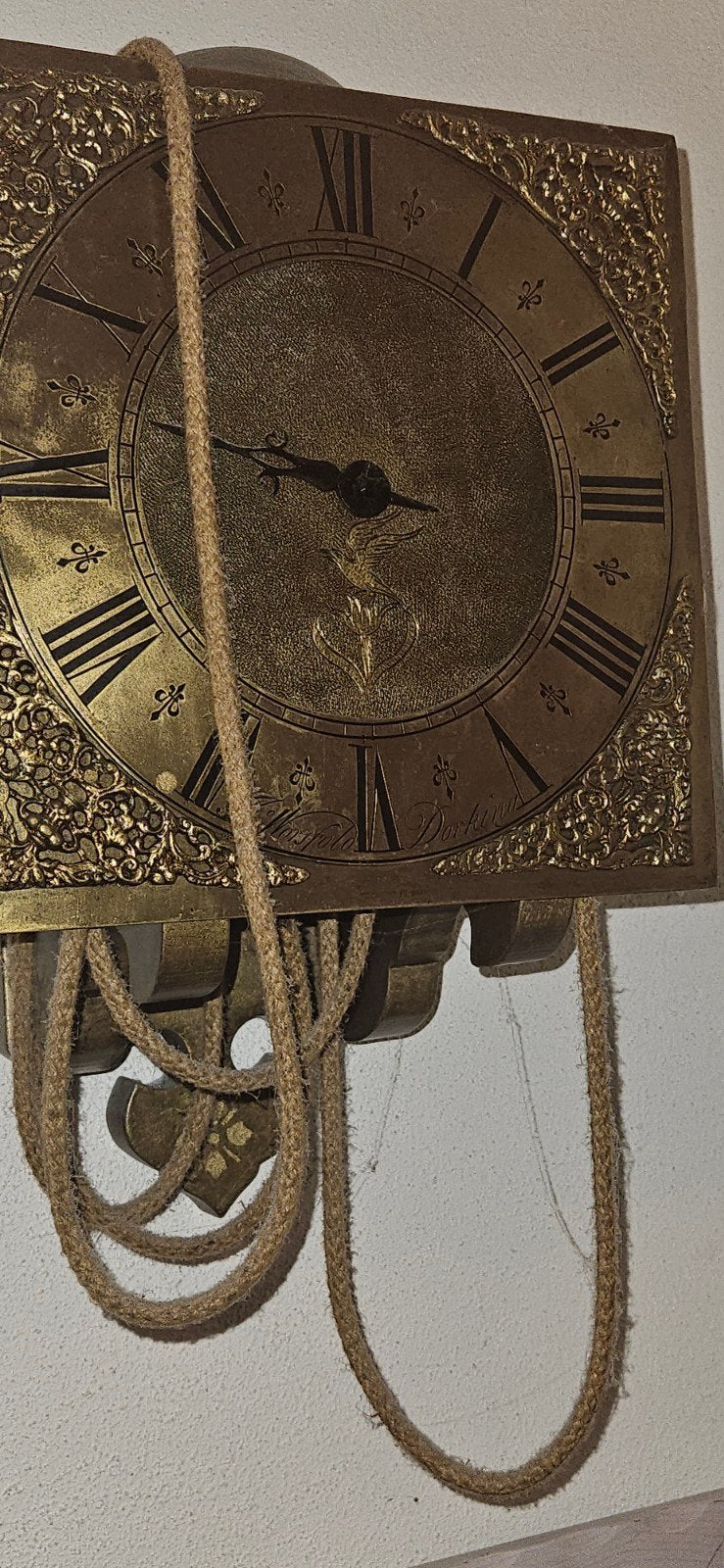Antieke koperen wandklok met touwmechanisme, Ophalen