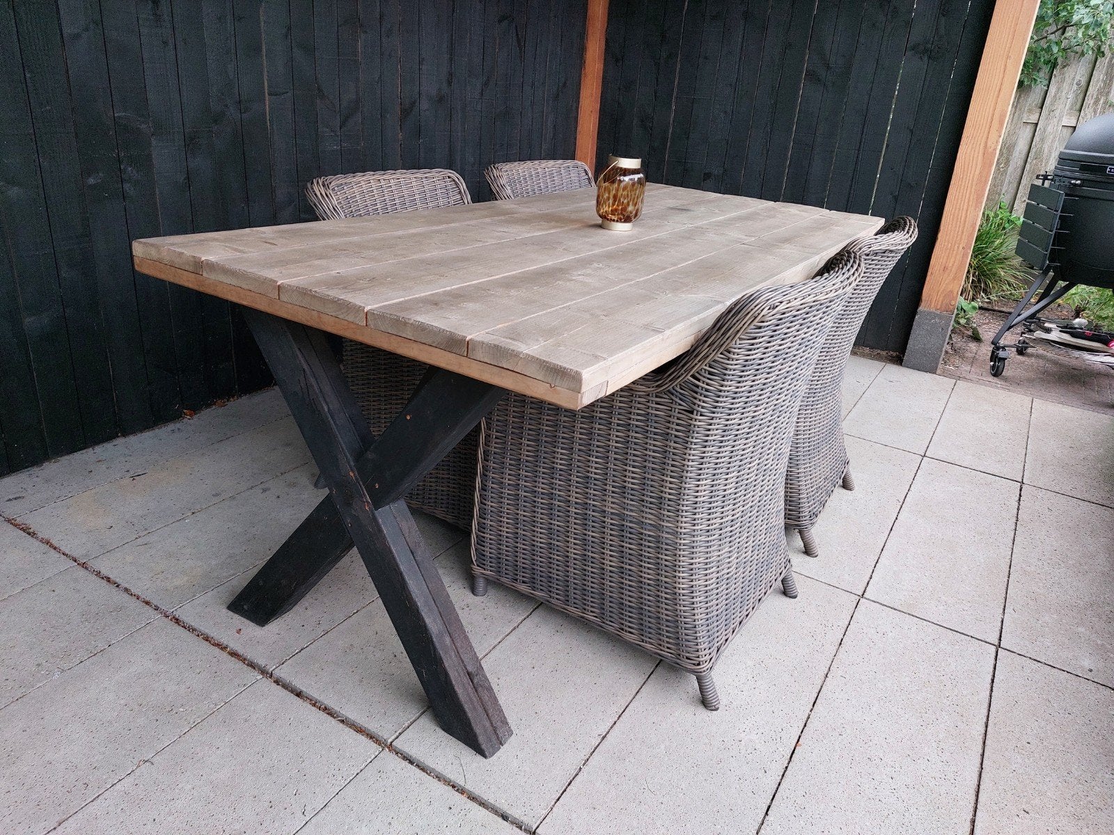 Foto 4 van Robuuste houten tuintafel met X-poten en 4 wicker stoelen