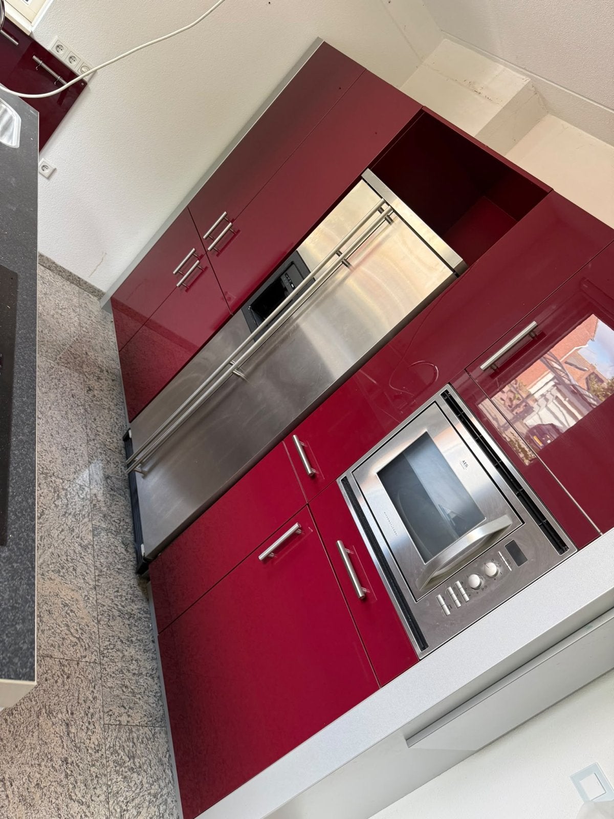 Moderne rode keuken met kookeiland en apparatuur
