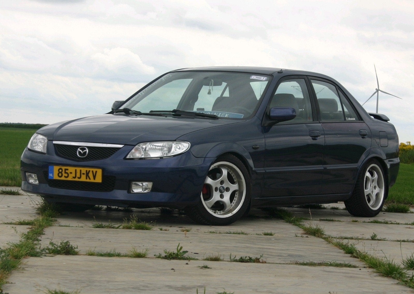 Mazda 323 1.6 SDN Touring AUT 2002 Blauw met spoiler. lees!!, Stof, 49 €/maand, Origineel Nederlands, 1200 kg