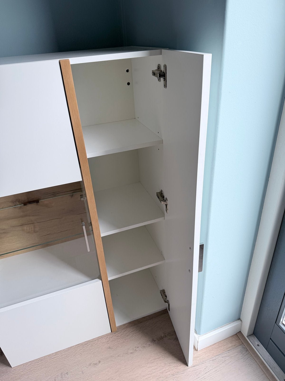 Foto 4 van Witte wandkast met glazen vitrine en houten accenten