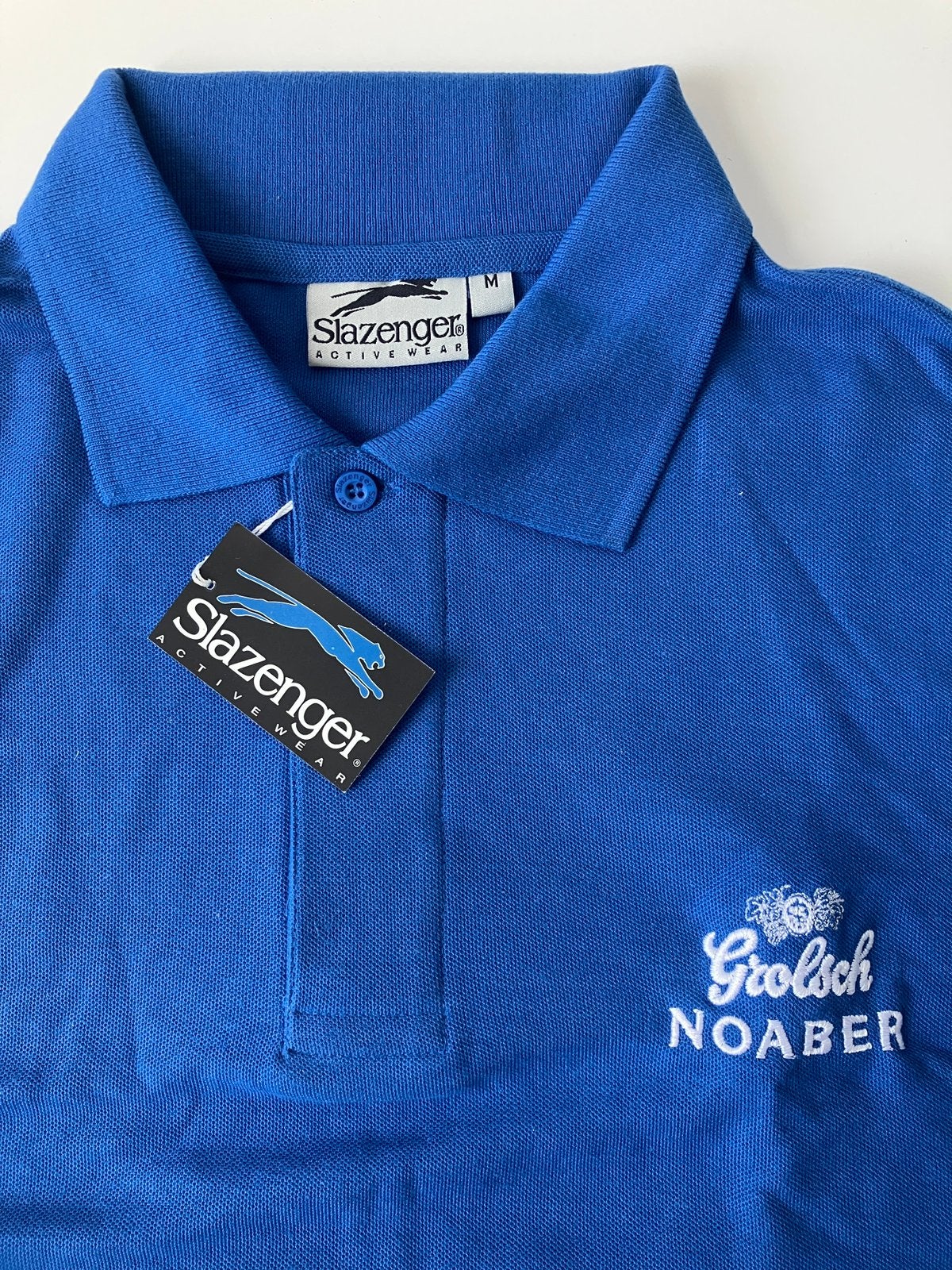 Grolsch Noaber korenblauwe polo, merk Slazenger, maat M, Verzamelen, Ophalen of Verzenden, Nieuw, Kleding, Grolsch