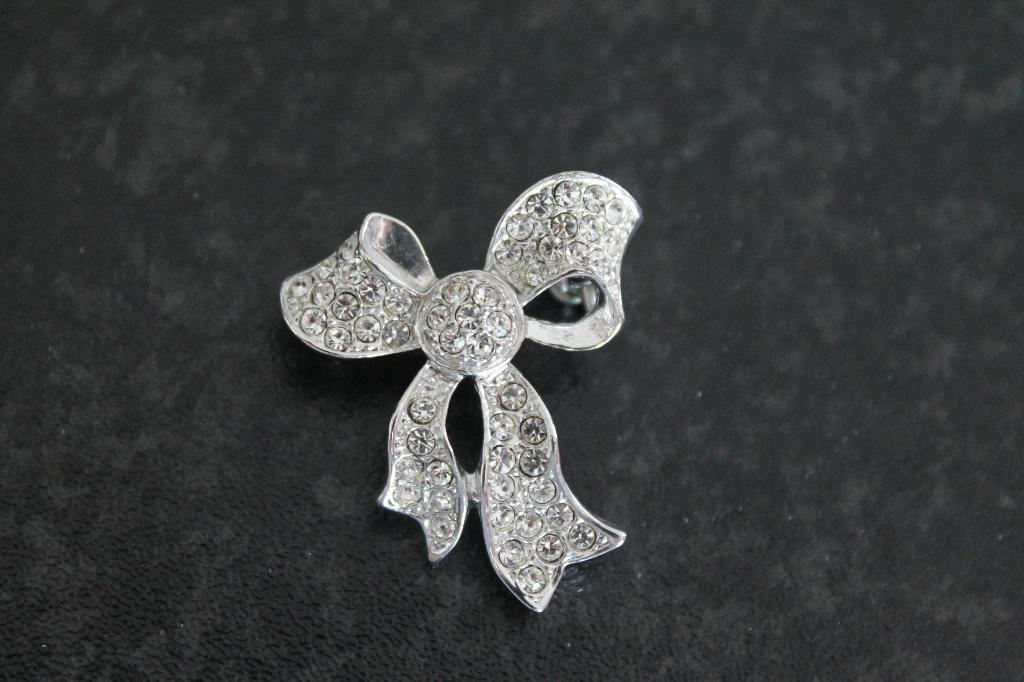 Broche, model strik, zilverkleurig met strass 3 x 2,5 cm, Overige materialen, Minder dan 4 cm, Ophalen of Verzenden, Zo goed als nieuw