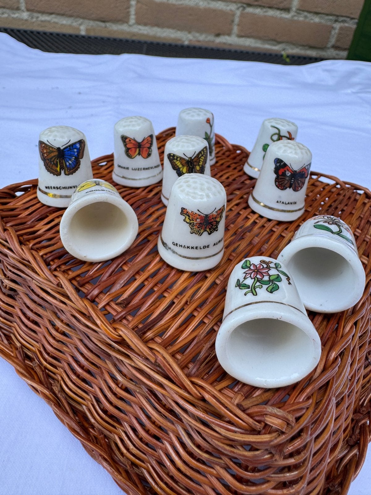 10 Vingerhoedjes met vlinders en bloemen in mandje, Ophalen of Verzenden, Gebruikt, Porselein, Nederland