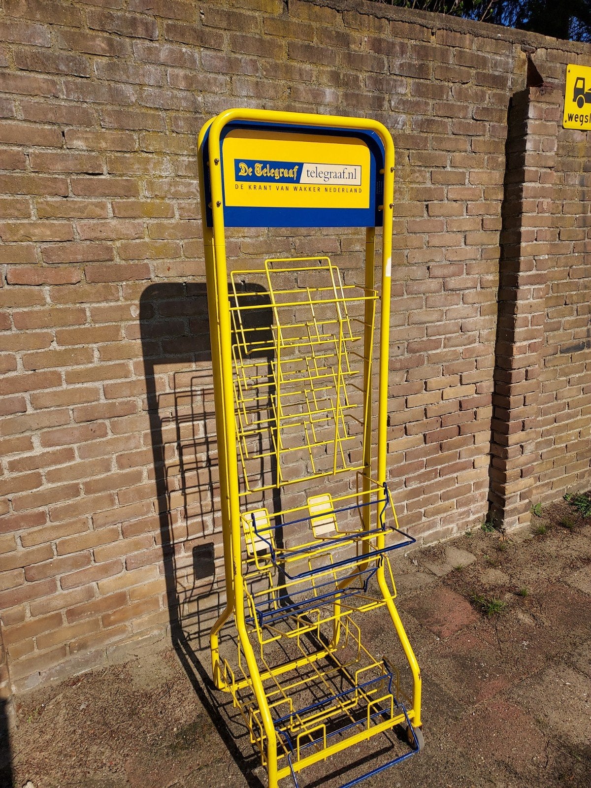 Stevig geel Telegraaf magazine- en krantenrek, Ophalen