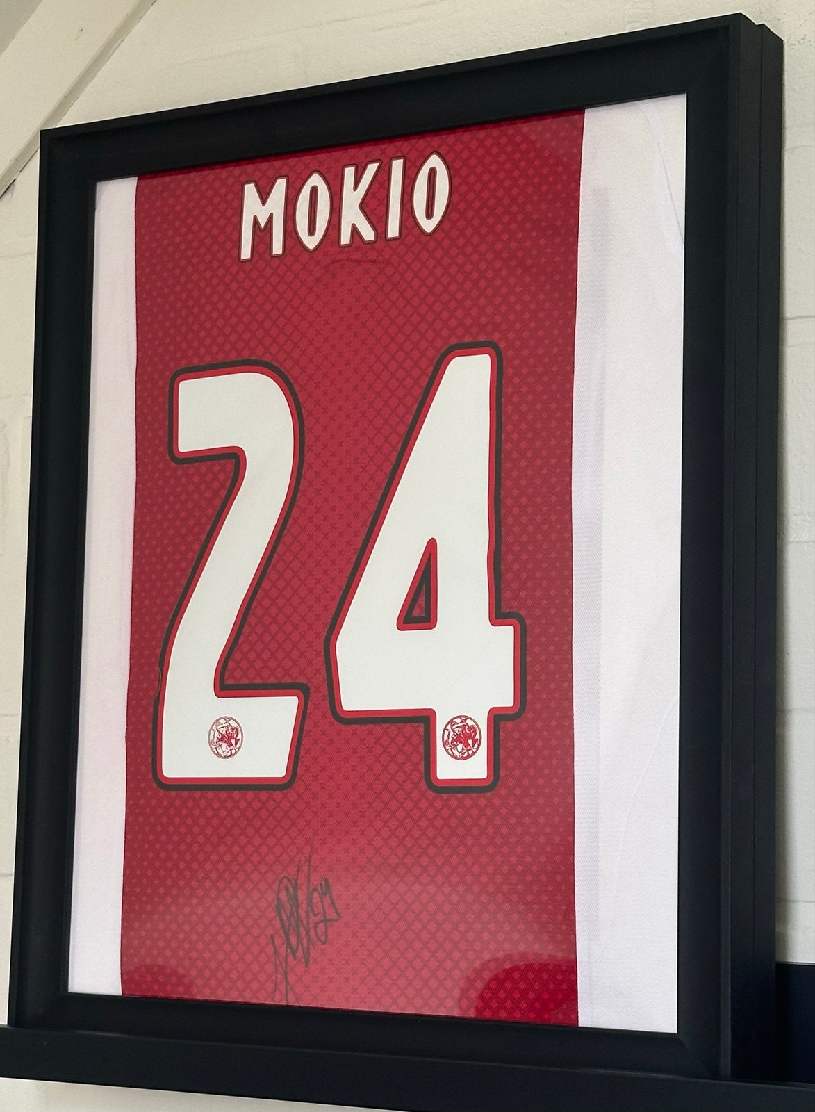 Ingelijst gesigneerd voetbalshirt Mokio #24, Huis en Inrichting, Woonaccessoires | Schilderijen, Tekeningen en Foto's, Zo goed als nieuw