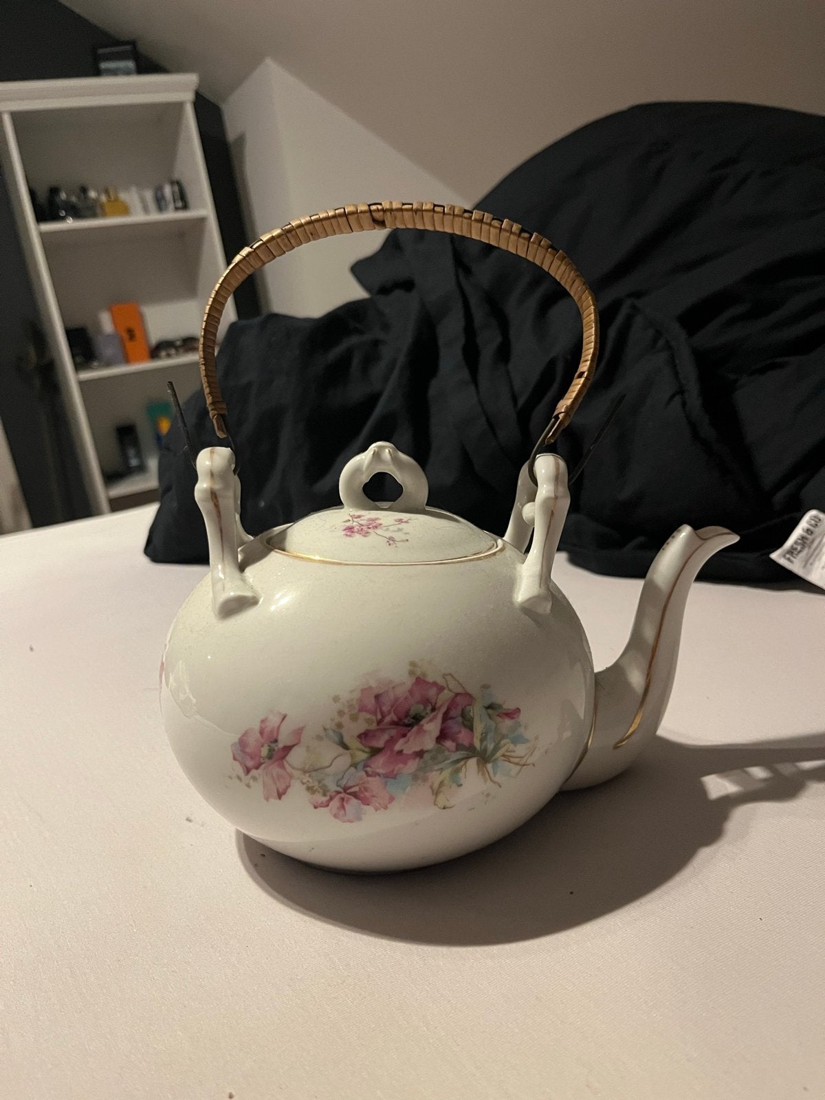 Vintage porseleinen theepot met bloemmotief en rotan handvat, Antiek en Kunst, Ophalen of Verzenden