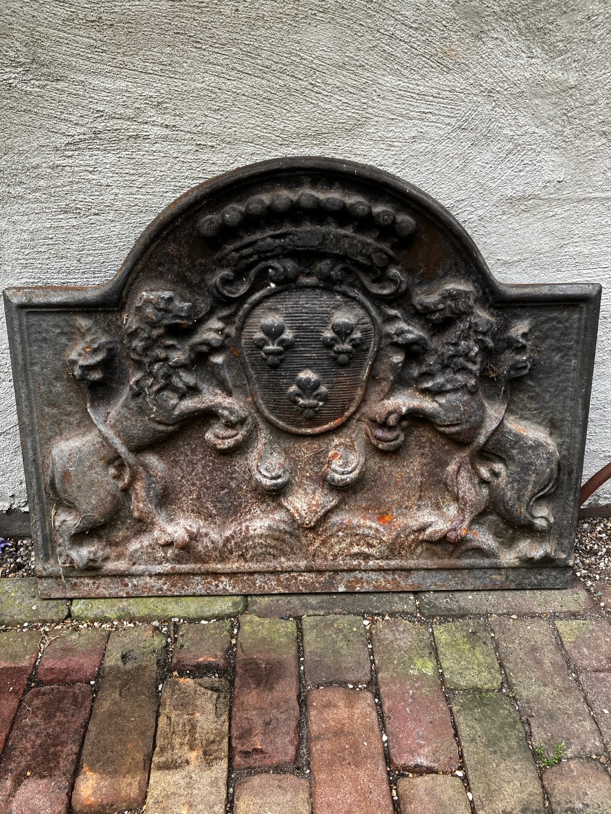Antieke gietijzeren haardplaat met wapenschild en leeuwen, Ophalen