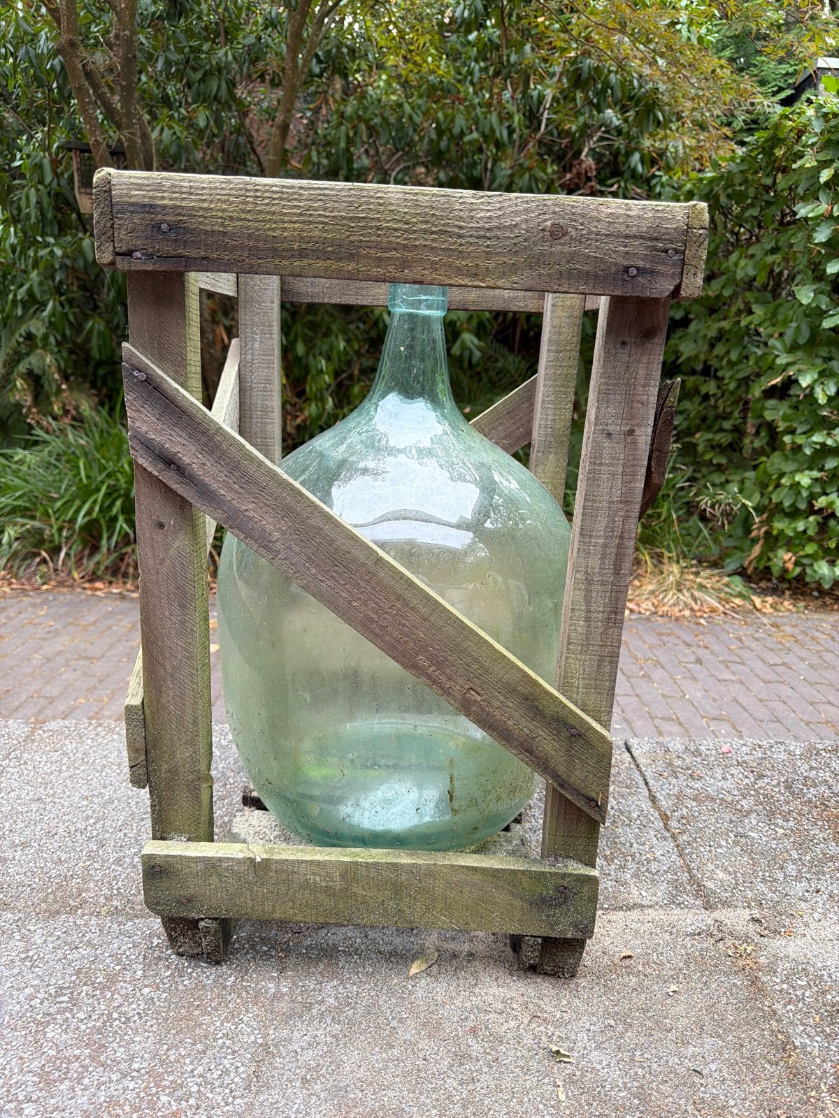 Grote glazen vaas in houten krat, Ophalen