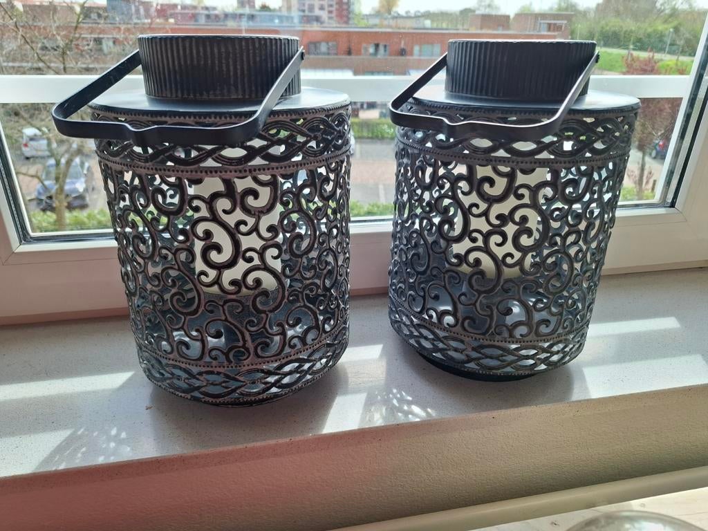 Twee windlichten met sierlijk patroon, Ophalen