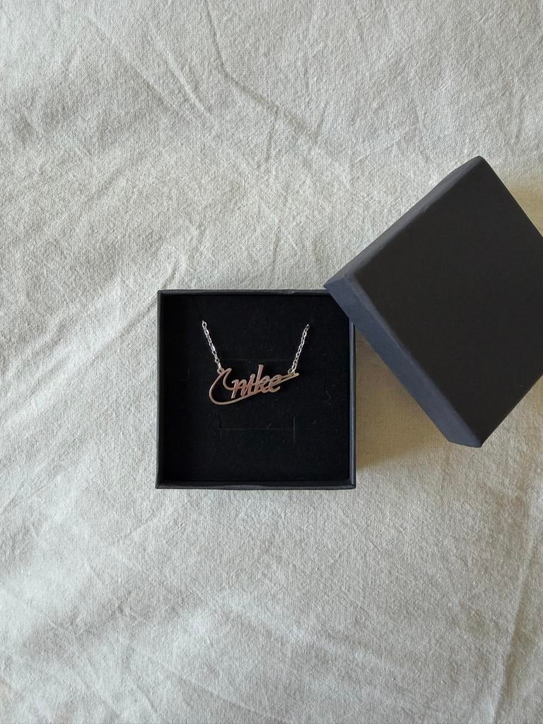 Zilverkleurige ketting met 'Nike' hanger, Ophalen of Verzenden, Nieuw, Zilver, Met hanger