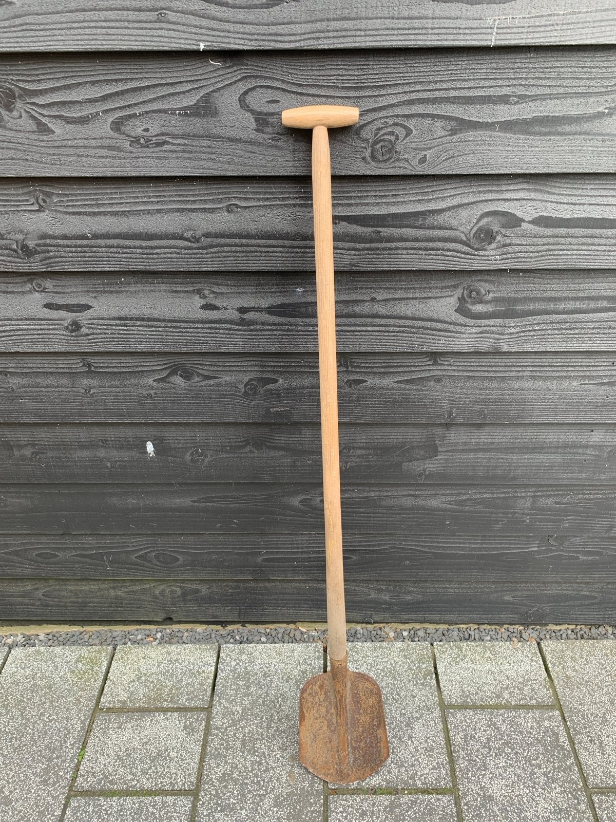 Oude roestige schep met houten steel, Ophalen
