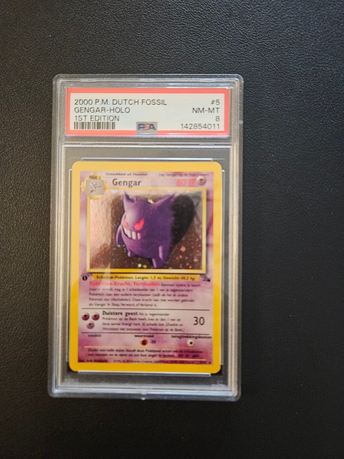 Gengar 1st Edition PSA 8 Fossil Dutch, Ophalen of Verzenden, Zo goed als nieuw, Losse kaart, Foil