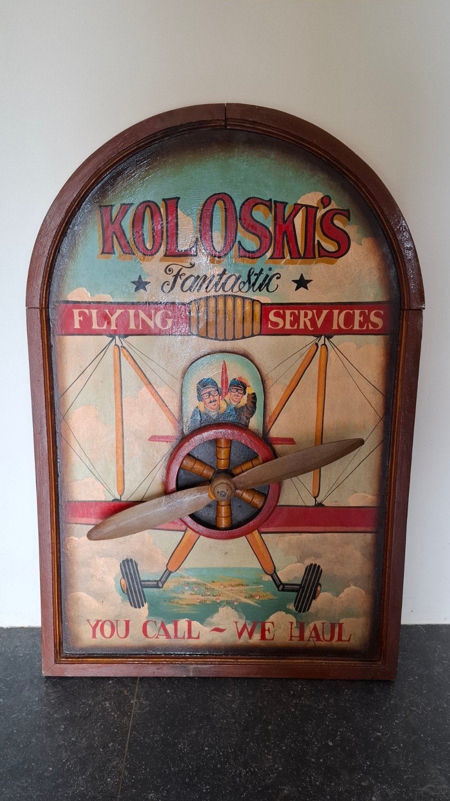 Koloski's Fantastic Flying Services Houten Plaque, Ophalen