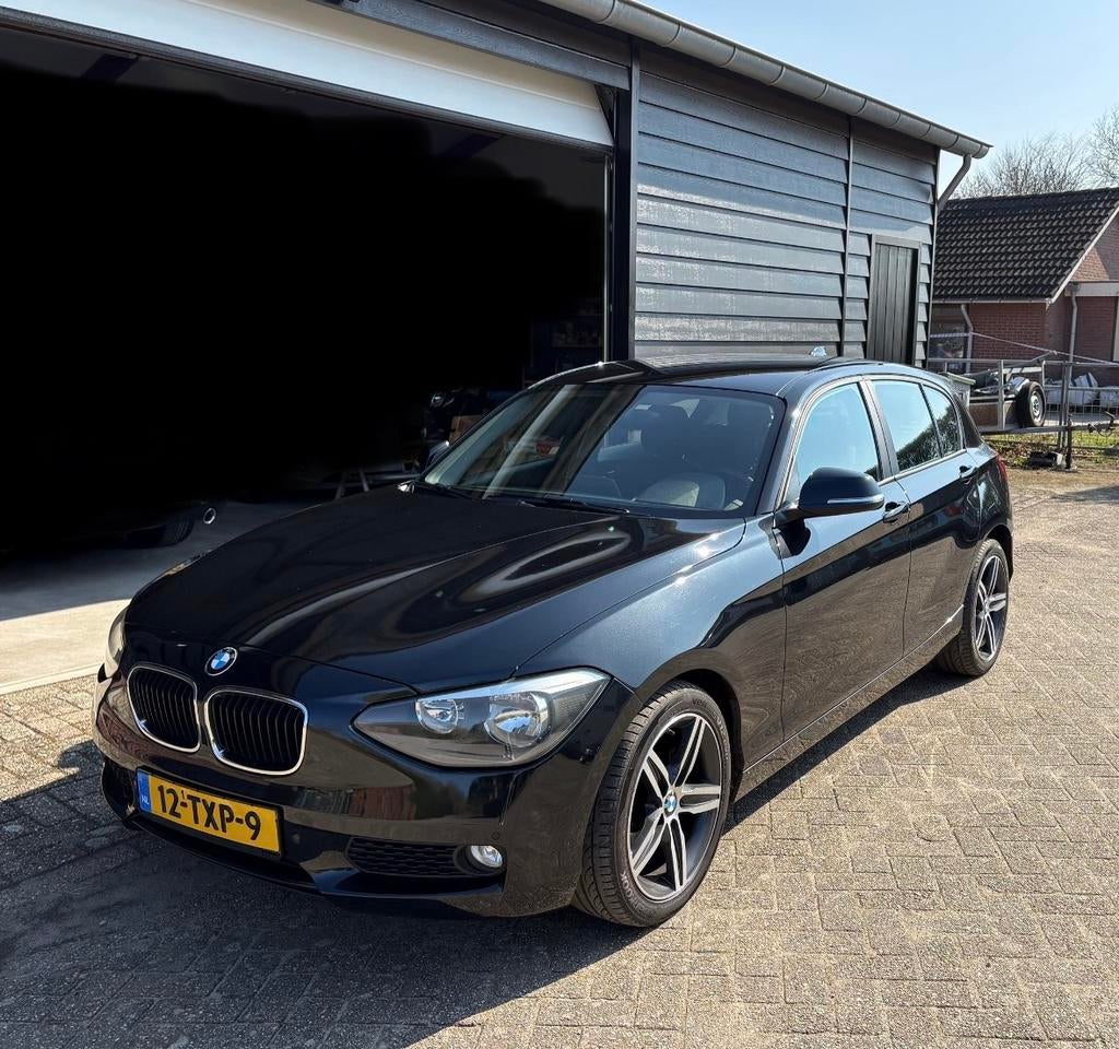 BMW 1-Serie 116I 100KW 5DR Aut8 2012 Zwart, Auto's, 4 cilinders, Zwart, Origineel Nederlands, 1200 kg