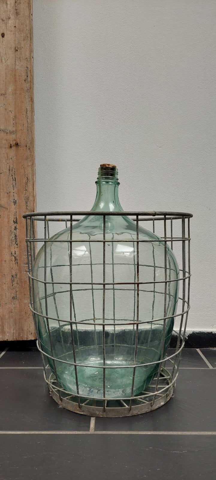 oude wijnfles in de originele metalen mand, Ophalen