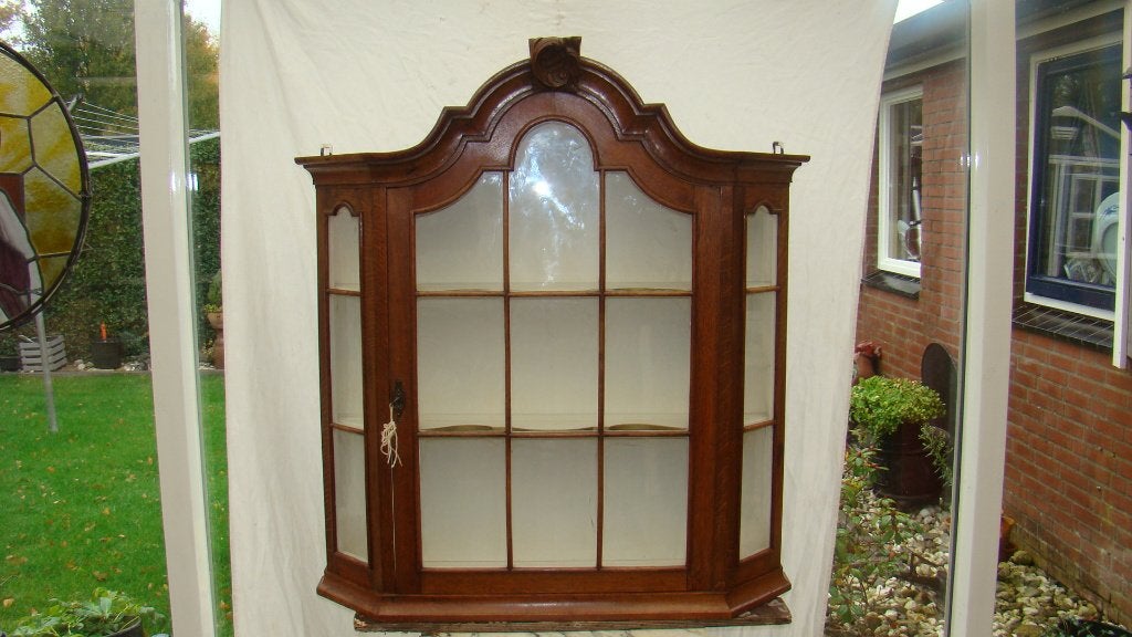 Vitrinekast met een elegant gebogen design en glazen deuren., Ophalen of Verzenden