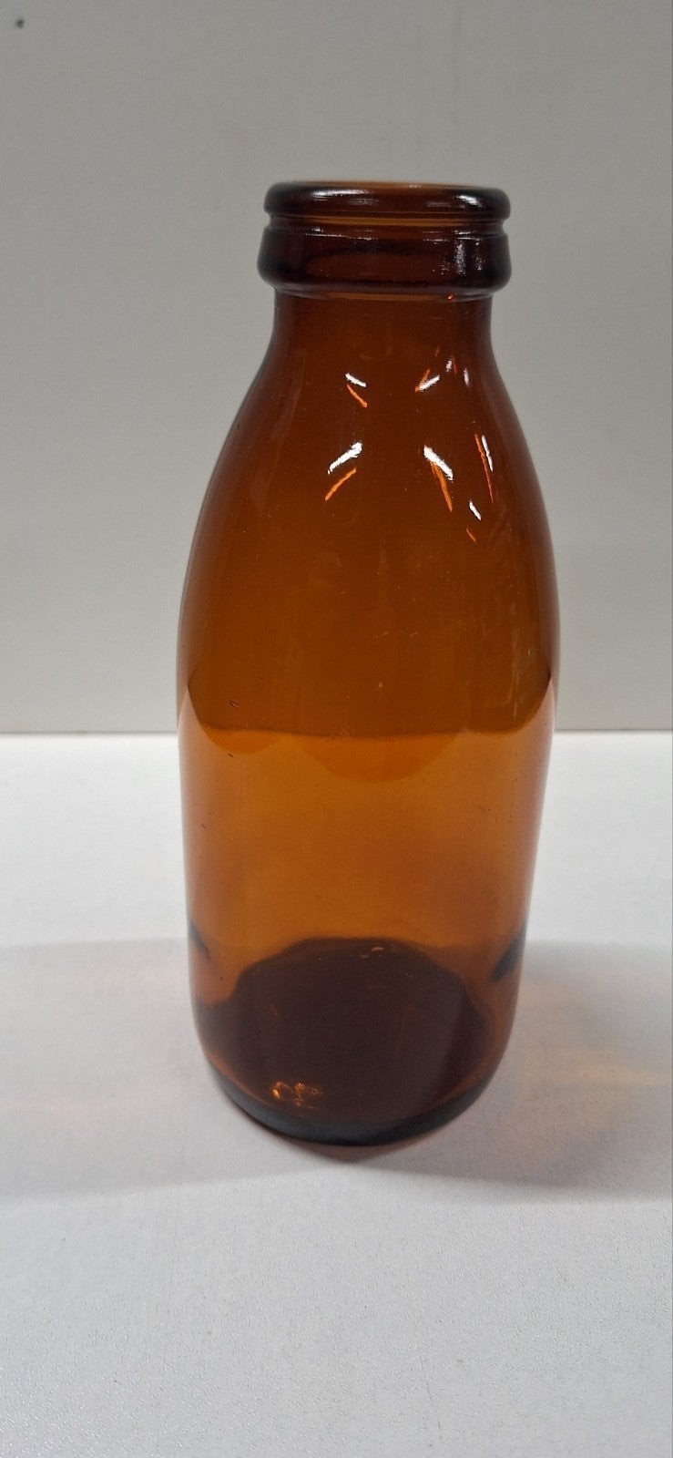 Vintage bruine glazen melkfles met D.K.F. reliëf, Ophalen of Verzenden