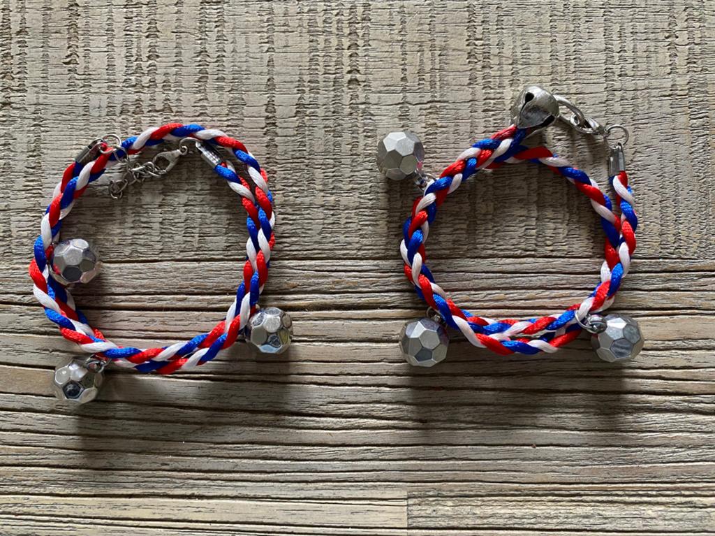 Twee rood wit blauwe armbanden met voetbal bedels, Ophalen of Verzenden, Zo goed als nieuw, Met bedels of kralen