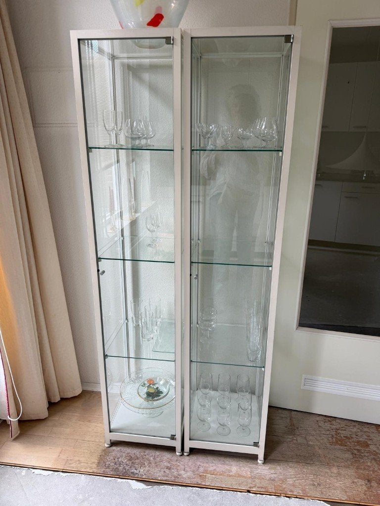 Twee glazen vitrinekasten met planken