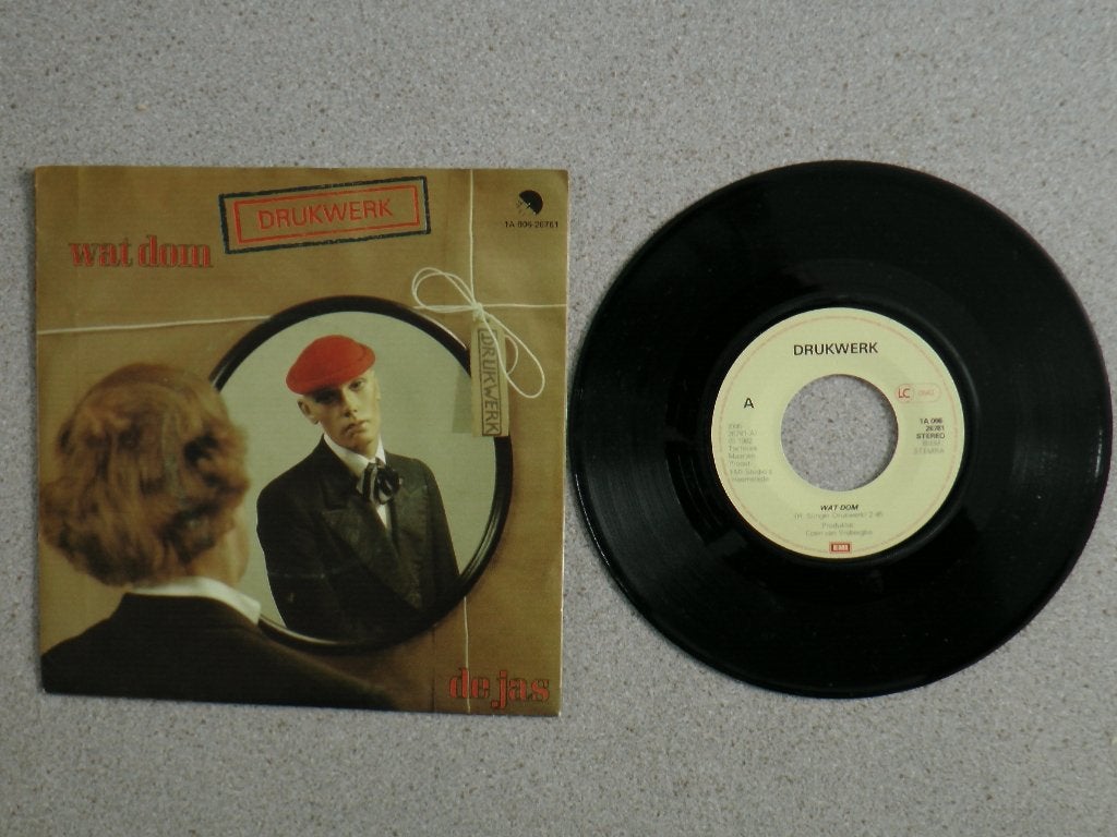 Drukwerk - Wat dom VINYL SINGLE, Fotohoes, Ophalen of Verzenden, Gebruikt, Pop