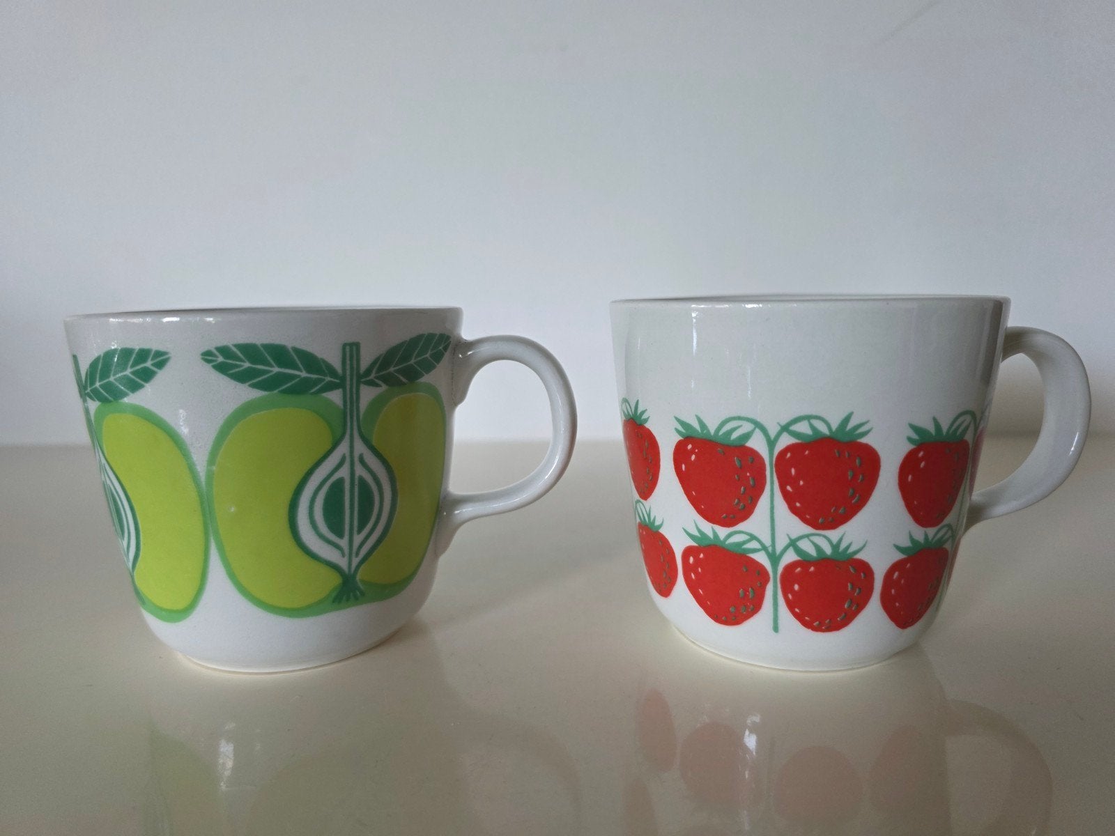 2 Vintage Arabia Finland mokken, met aardbeien en appels, Keramiek, Ophalen of Verzenden, Overige stijlen, Kop(pen) en/of Schotel(s)