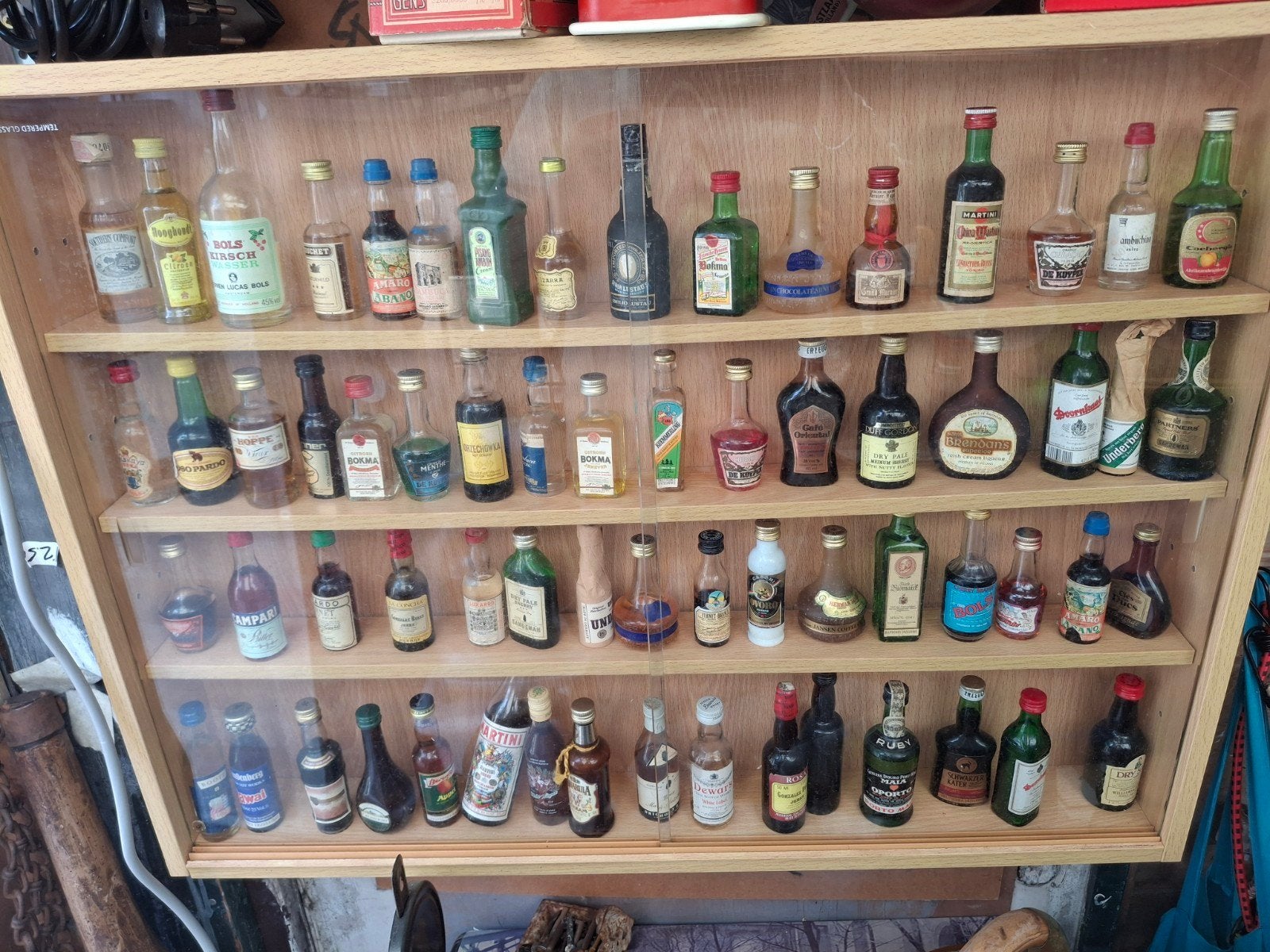 Verzameling van mini-alcoholflessen in vitrinekast, Ophalen