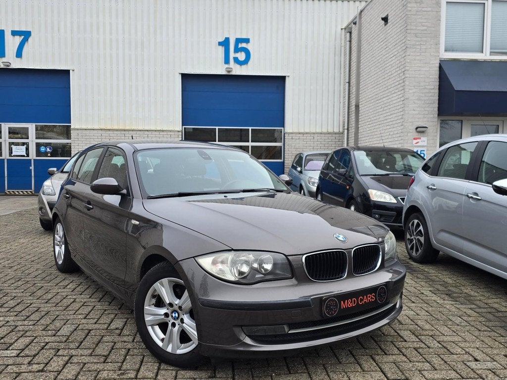BMW 1-serie 118i Business Line AUTOMAAT/NAP/AIRCO/CR CONTROL, Auto's, BMW, Zwart, Bruin, Origineel Nederlands, 650 kg