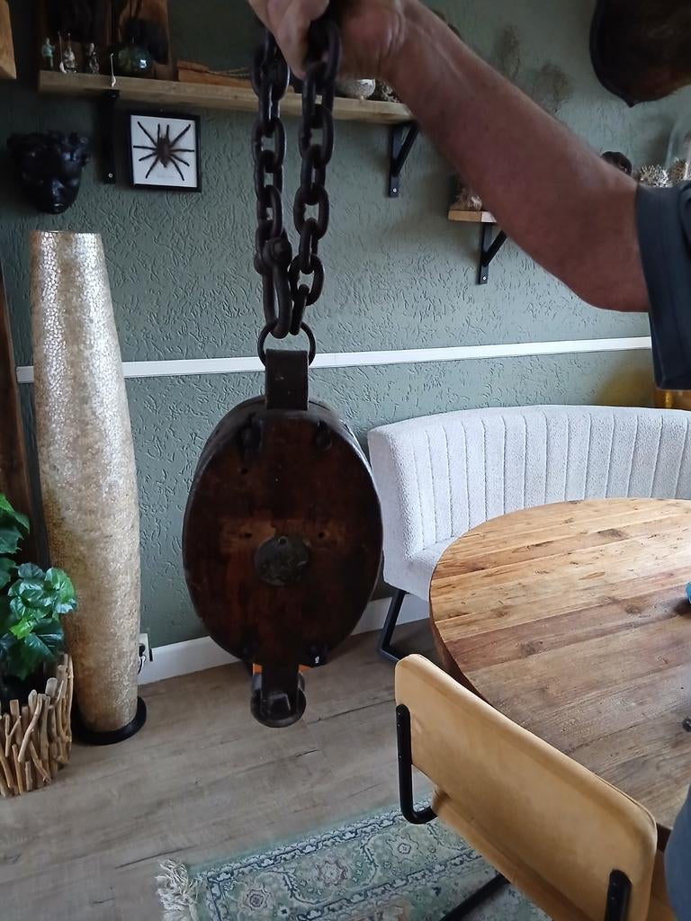 Oude houten katrol met ketting, Ophalen
