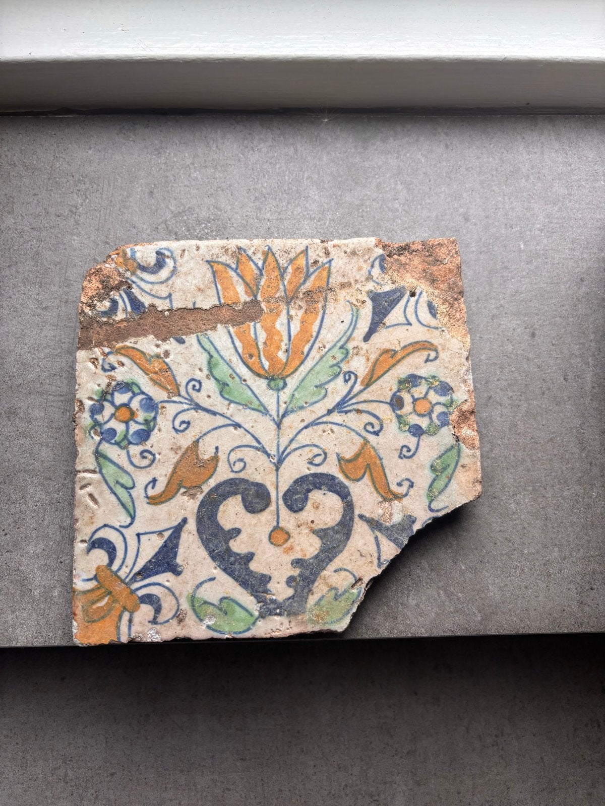 Antieke tegel uit de 17e eeuw met bloemmotief, Antiek en Kunst, Antiek | Wandborden en Tegels, Ophalen of Verzenden