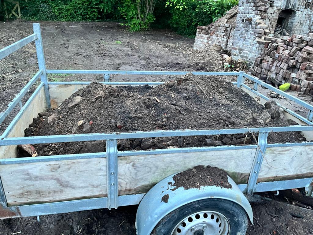 Grond met puinresten, klaar om op te halen, Ophalen, Tuinaarde