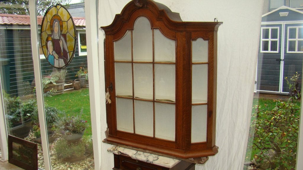 Vitrinekast met een elegant gebogen design en glazen deuren., Ophalen of Verzenden