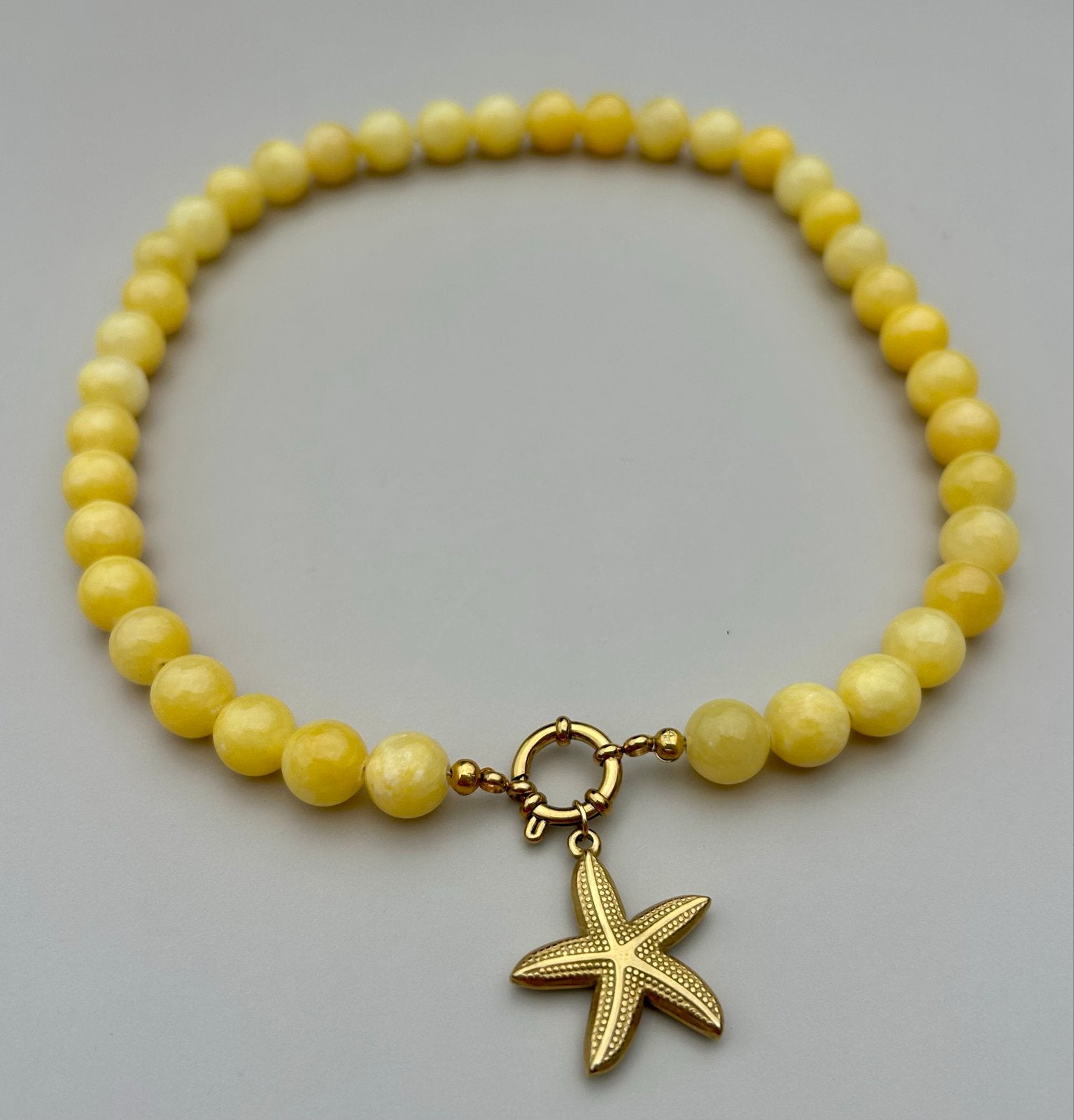 Gele kralen ketting met gouden zeester hanger, Geel, Ophalen of Verzenden, Zo goed als nieuw, Overige materialen