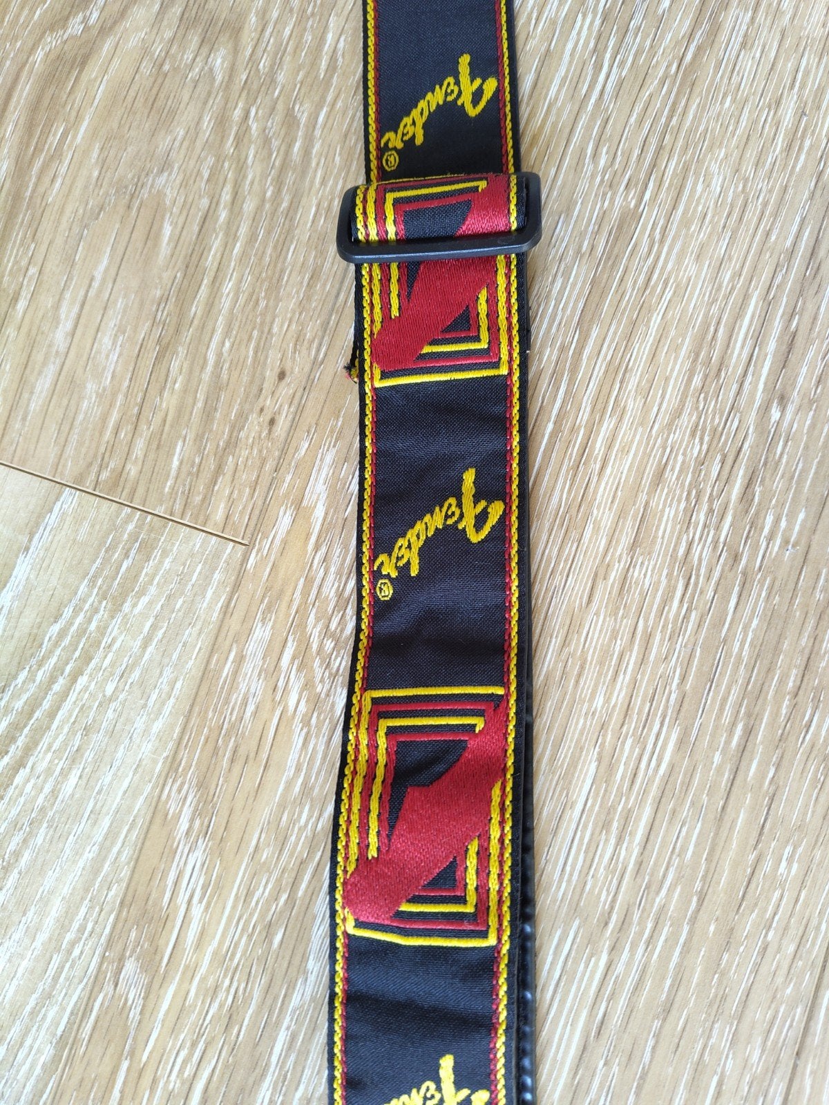 Fender gitaarband - Zwart met rood en geel logo