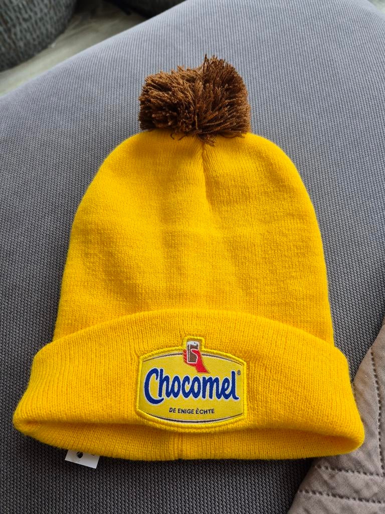Chocomel Muts met Pompon - Geel, Kleding | Dames, Mutsen, Sjaals en Handschoenen, Nieuw, Muts, Maat 38/40 (M), Ophalen of Verzenden