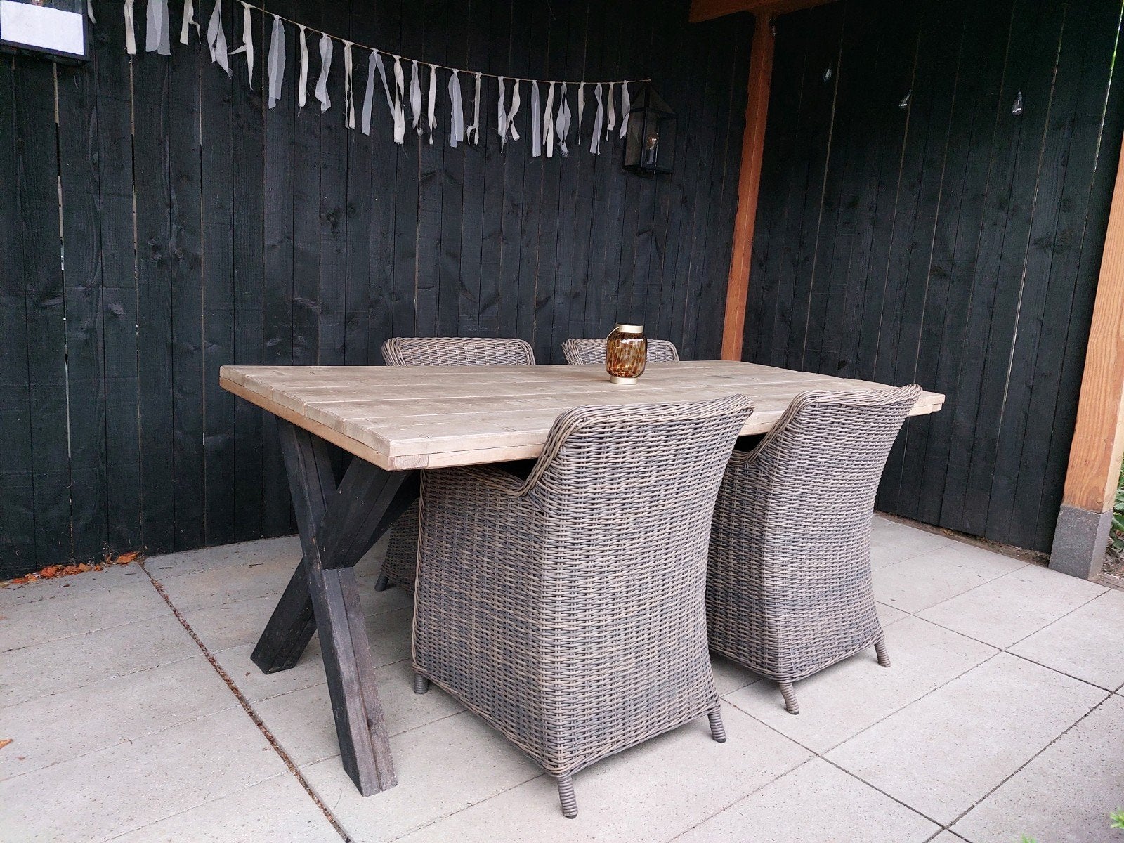 Foto 2 van Robuuste houten tuintafel met X-poten en 4 wicker stoelen