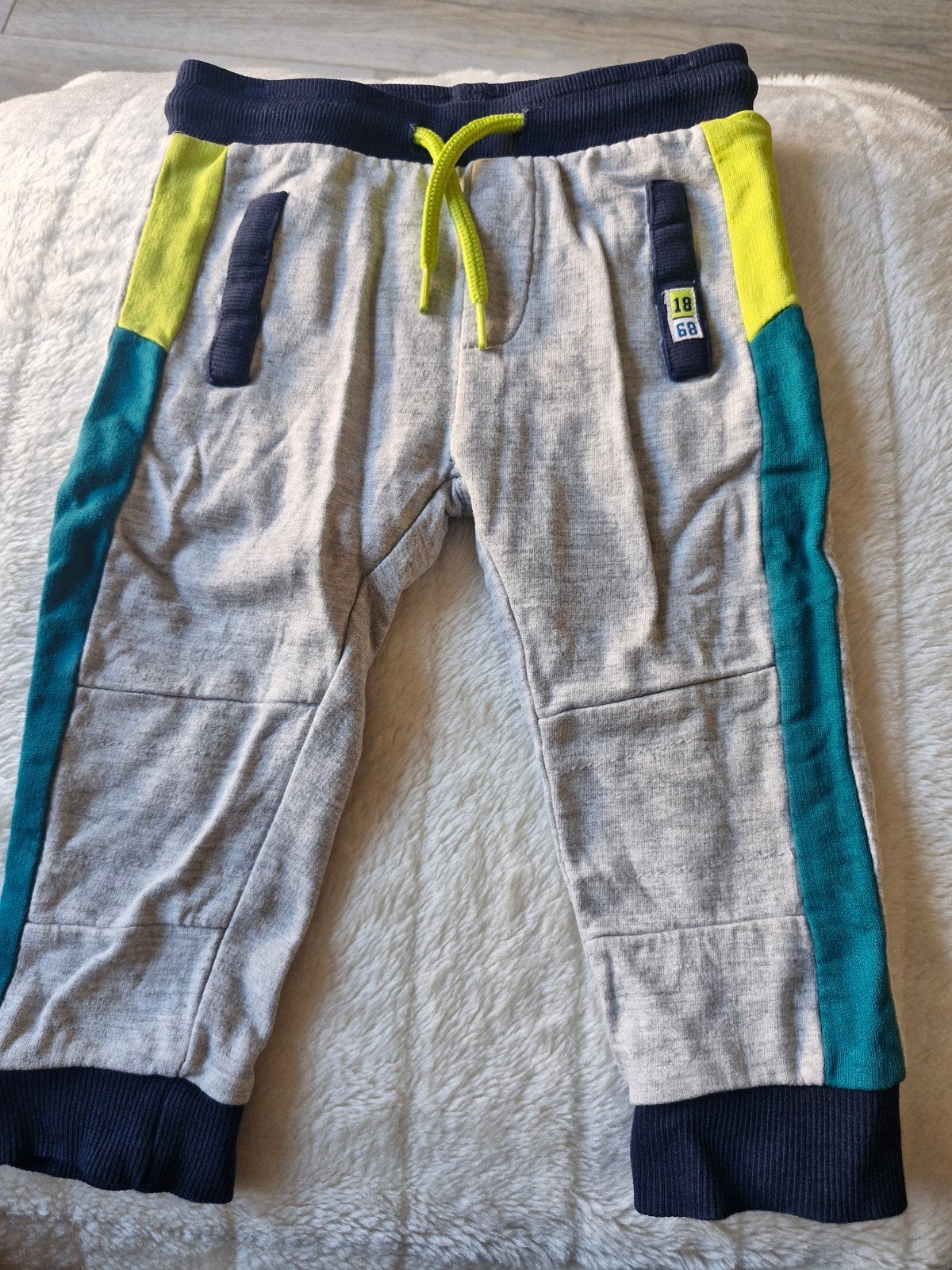 Grijze joggingsbroek met blauw en geel maat 80, Broekje, Baby Blue, Onbekend, Ophalen of Verzenden