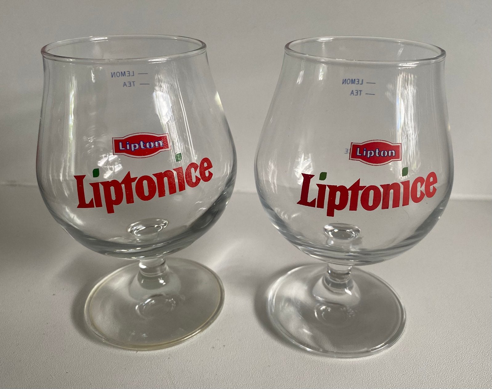 2x Lipton Liptonice glazen op voet. Hoogte 13 cm., Ophalen of Verzenden, Zo goed als nieuw, Frisdrankglas
