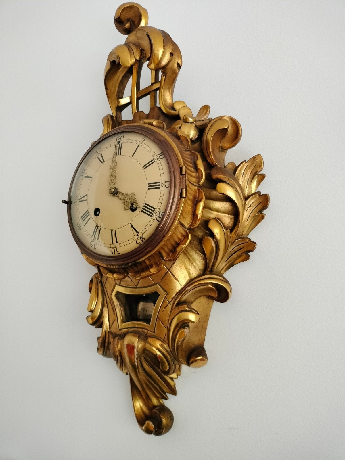 Antieke vergulde wandklok met sierlijke details, Ophalen of Verzenden