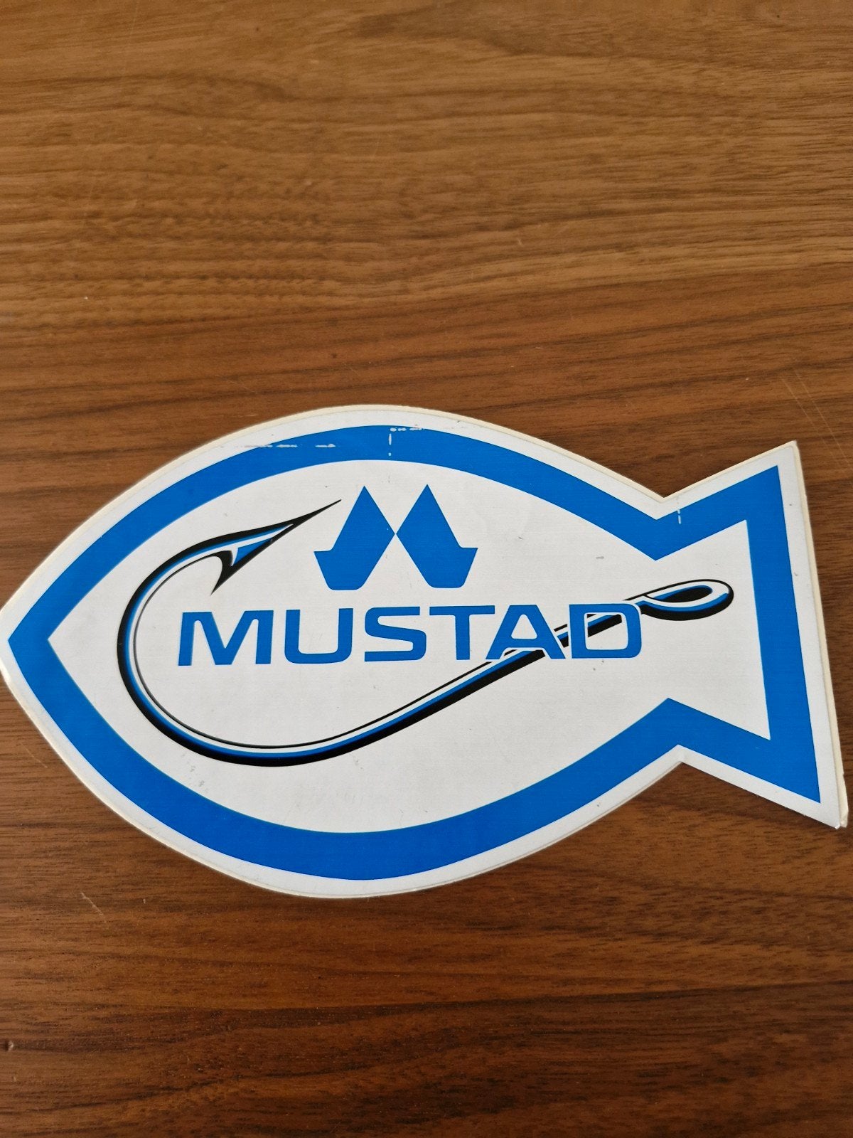 557 Mustad Vissers Sticker - Visvormig Logo, Ophalen of Verzenden, Zo goed als nieuw, Merk
