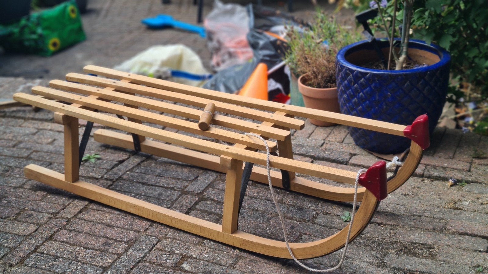 Houten slee met remmen en trekkoord, Ophalen