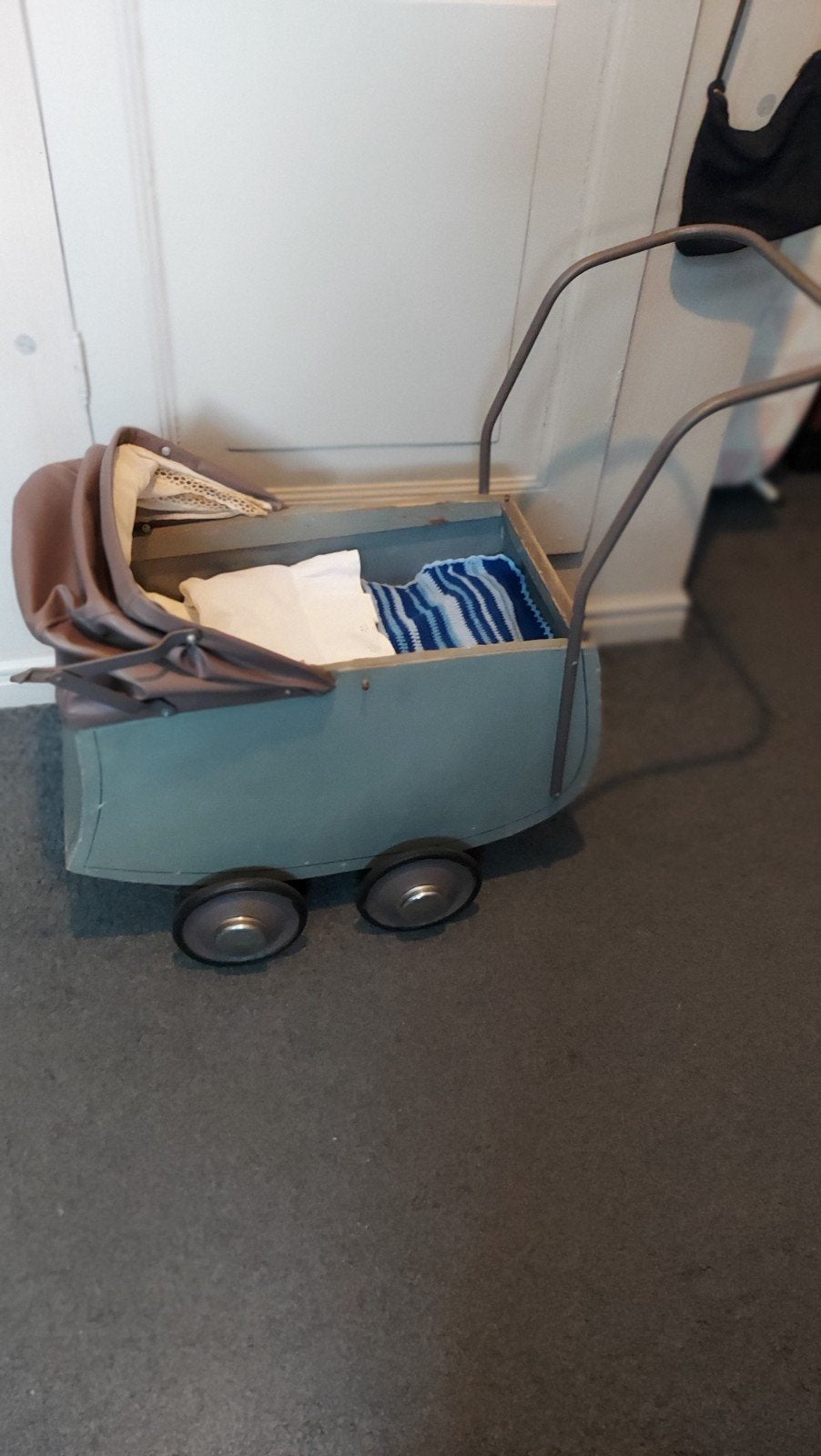 Antieke poppenwagen met beddengoed, Ophalen