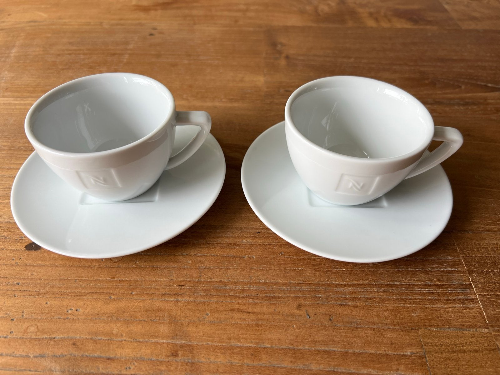 Nespresso kop en schotel set - 2 stuks, Gebruikt, Overige merken, Keramiek, Ophalen of Verzenden