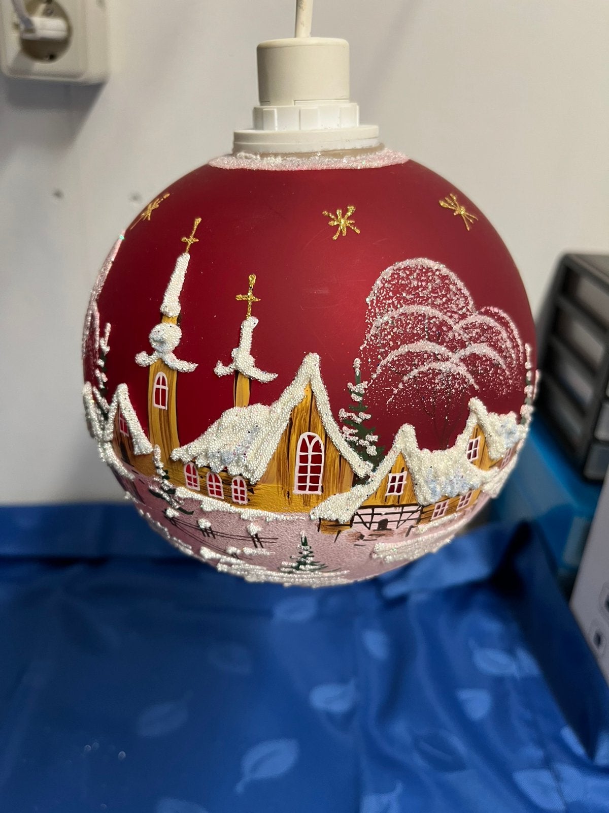 Verlichte Rode Glazen Kerstbal met een winterdorp er op., Diversen, Ophalen of Verzenden